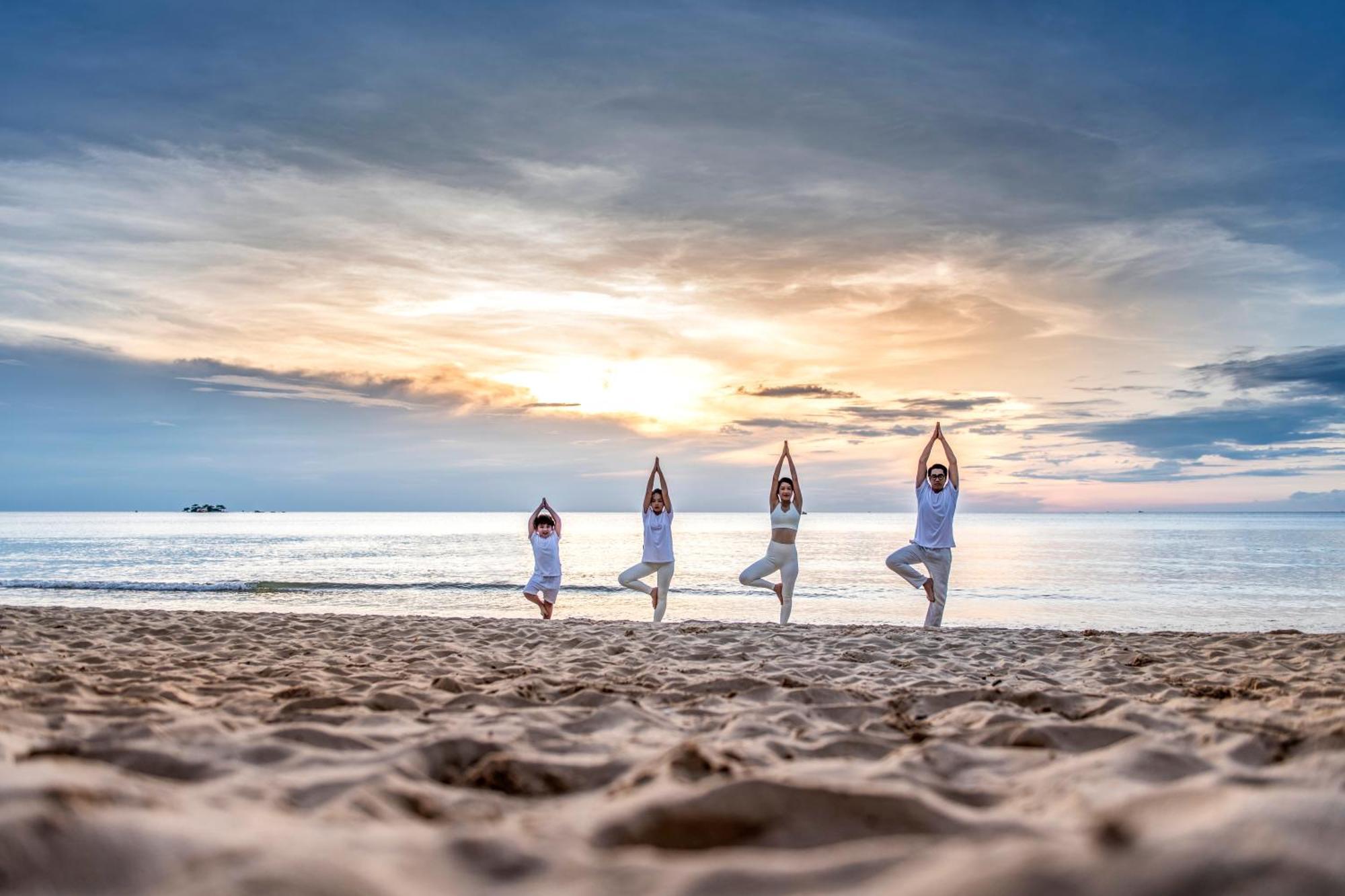 Vinpearl Resort & Spa Phu Quoc Extérieur photo Family practicing yoga on the beach